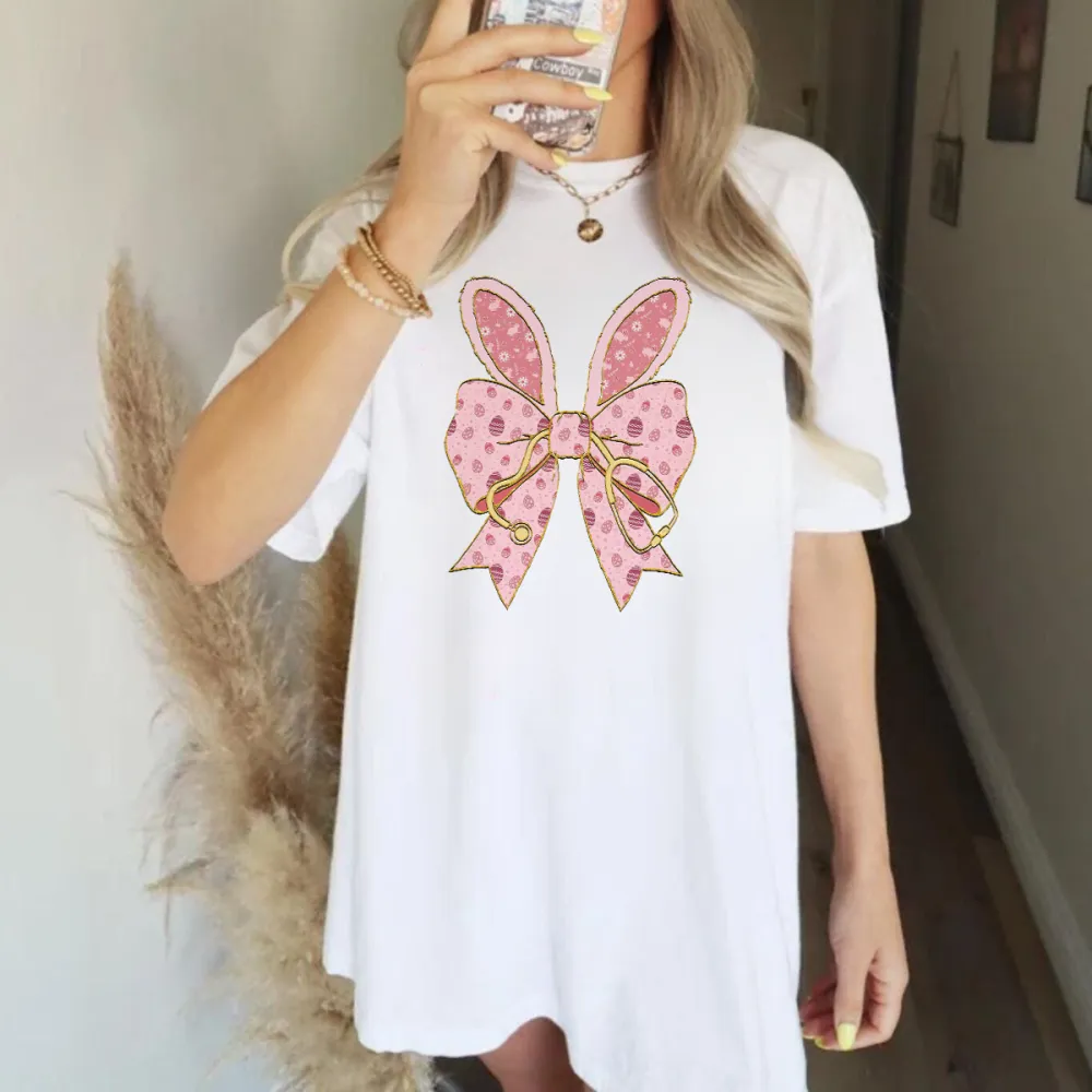 A Pink Bow Pattern With Bunny Ears And Pink Polka Dots, Hanging On A Golden Stethoscope And A Casual T-Shirt.